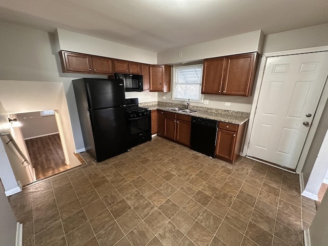 kitchen with light stone counters, sink, and black appliances