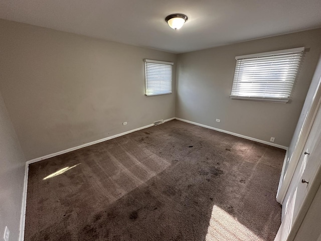 unfurnished room with dark carpet