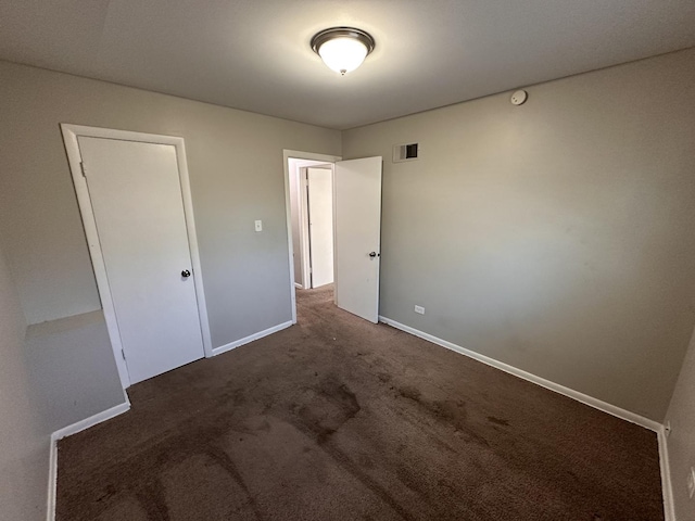 unfurnished bedroom with dark colored carpet