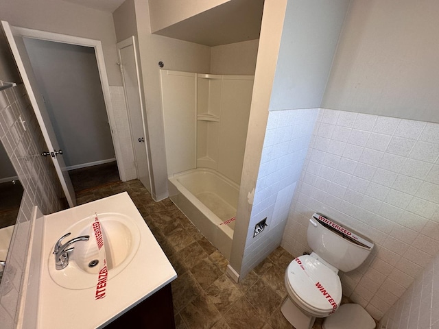 bathroom with vanity, toilet, a shower, and tile walls