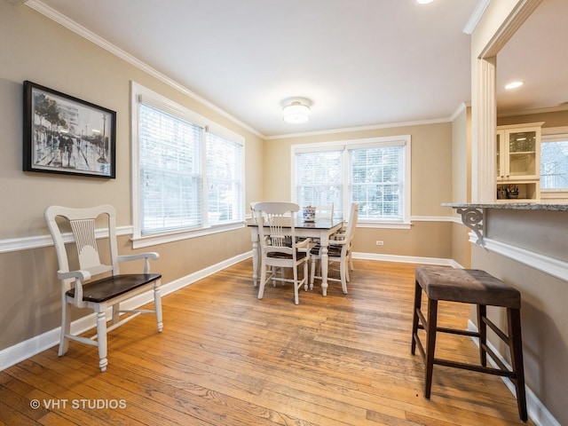 dining space with light hardwood / wood-style flooring and ornamental molding