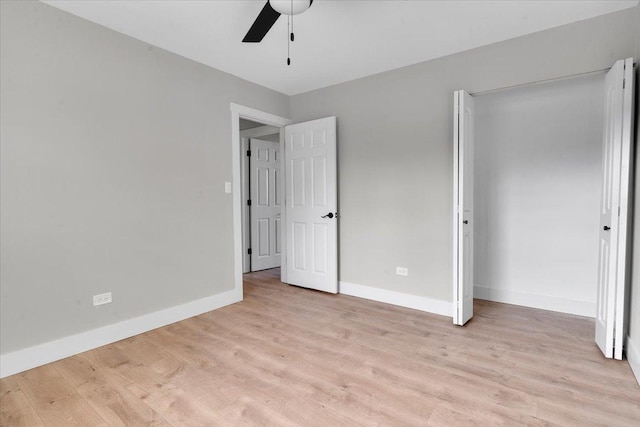 unfurnished bedroom featuring a closet, light hardwood / wood-style floors, and ceiling fan