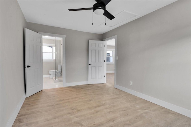 unfurnished bedroom with ceiling fan, ensuite bathroom, and light wood-type flooring