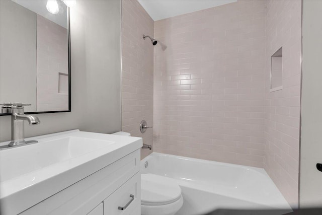 full bathroom with vanity, tiled shower / bath combo, and toilet