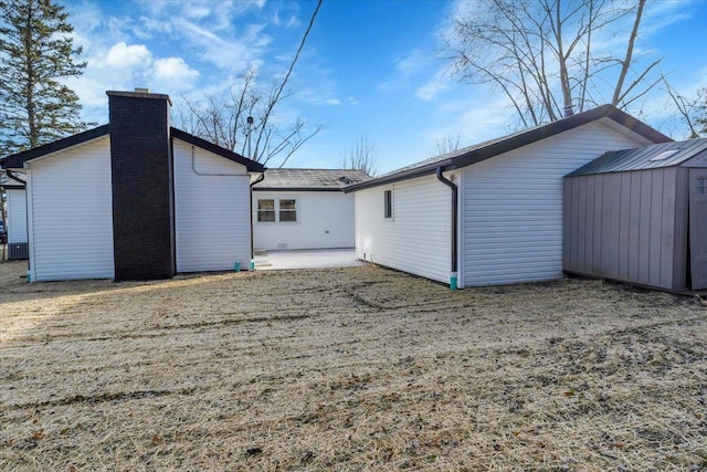 back of house with a patio area and a shed