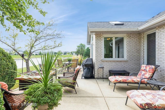 view of patio with a grill and a water view