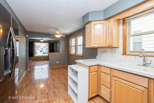 kitchen with stainless steel fridge, light wood-type flooring, backsplash, light brown cabinetry, and sink