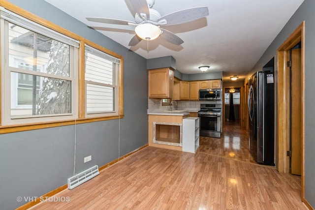 kitchen with sink, ceiling fan, light wood-type flooring, tasteful backsplash, and stainless steel appliances