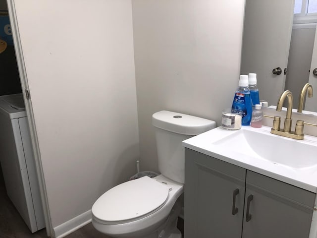 bathroom featuring washer / clothes dryer, vanity, and toilet