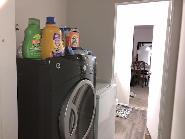 washroom with washer and dryer and wood-type flooring