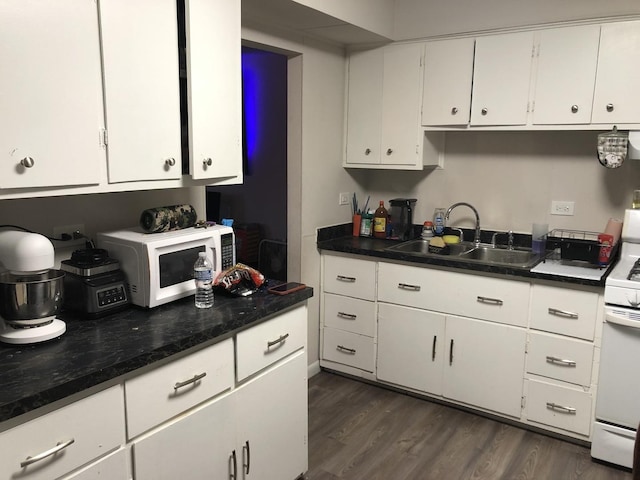 kitchen featuring white range, white cabinetry, and sink