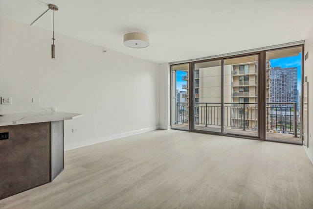 interior space featuring floor to ceiling windows and light wood-type flooring