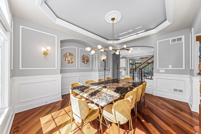 dining room featuring a raised ceiling, crown molding, and dark hardwood / wood-style flooring