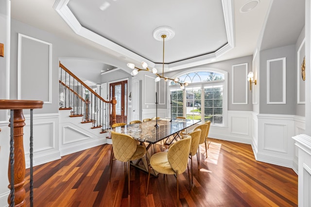 dining area featuring a tray ceiling, crown molding, and dark hardwood / wood-style flooring