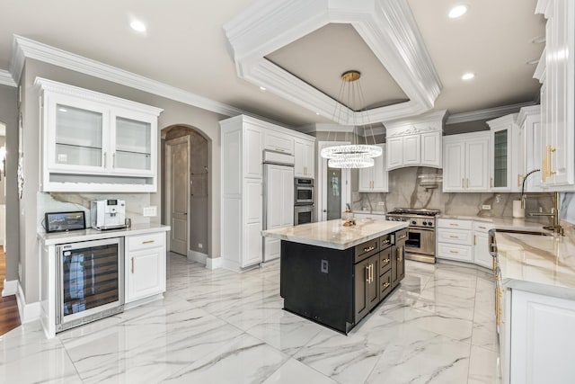 kitchen featuring white cabinetry, beverage cooler, hanging light fixtures, premium appliances, and a kitchen island