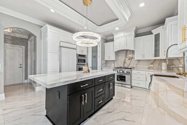 kitchen featuring white cabinetry, a center island, hanging light fixtures, crown molding, and appliances with stainless steel finishes