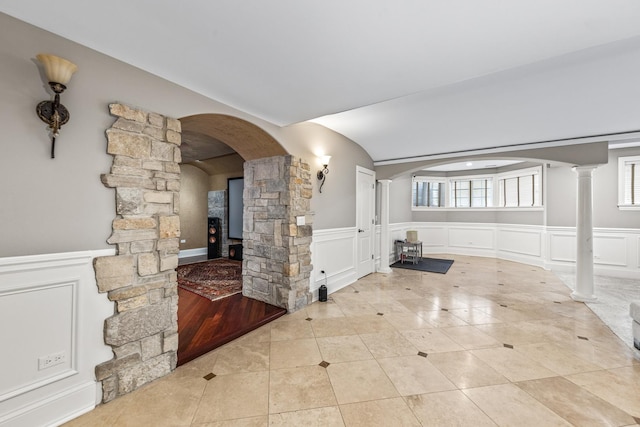 unfurnished living room with light tile patterned floors and decorative columns