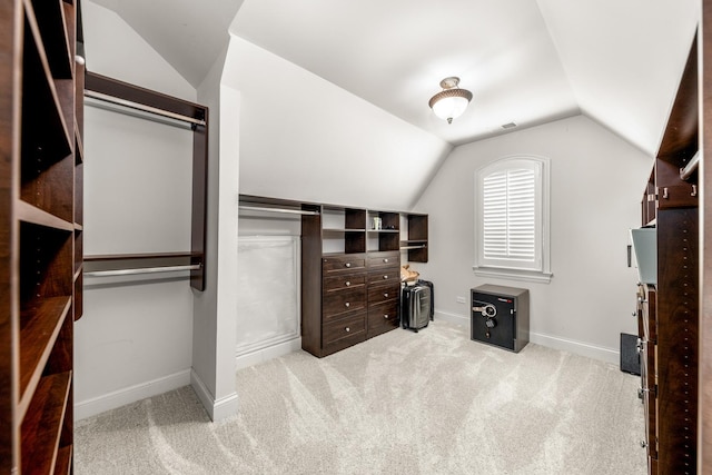 walk in closet featuring light carpet and lofted ceiling