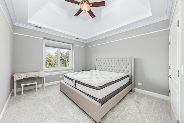 bedroom featuring a tray ceiling, crown molding, ceiling fan, and light colored carpet