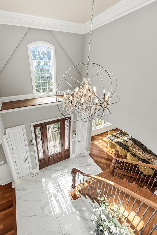 foyer featuring a chandelier and crown molding