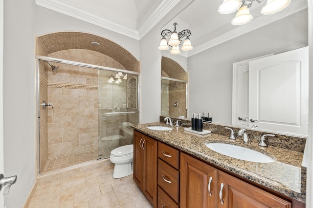 bathroom with vanity, toilet, a shower with shower door, and crown molding