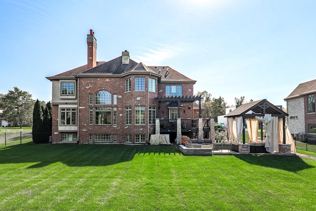 rear view of property featuring a lawn, outdoor lounge area, a pergola, and a gazebo