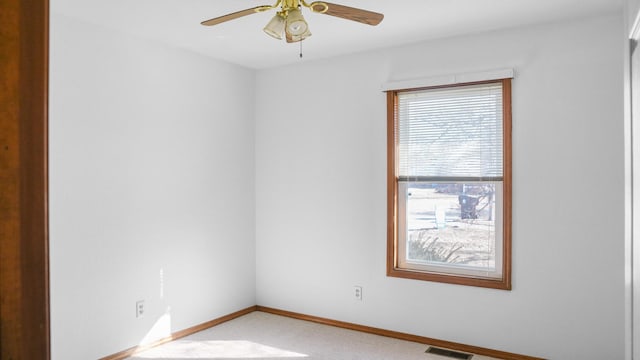 unfurnished room featuring a ceiling fan, light colored carpet, visible vents, and baseboards