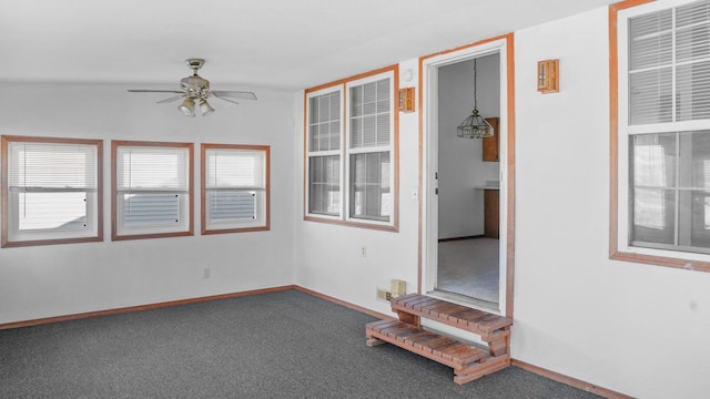 empty room with carpet floors, a healthy amount of sunlight, ceiling fan, and baseboards