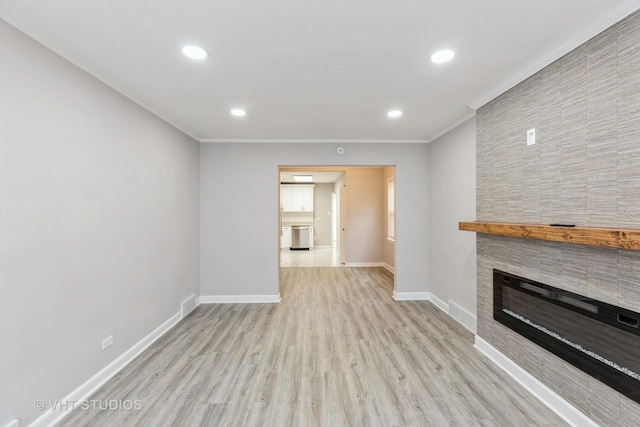 unfurnished living room featuring a fireplace, light hardwood / wood-style floors, and ornamental molding