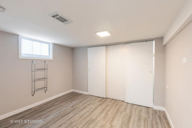 basement with light hardwood / wood-style flooring