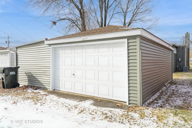 snow covered garage featuring central air condition unit