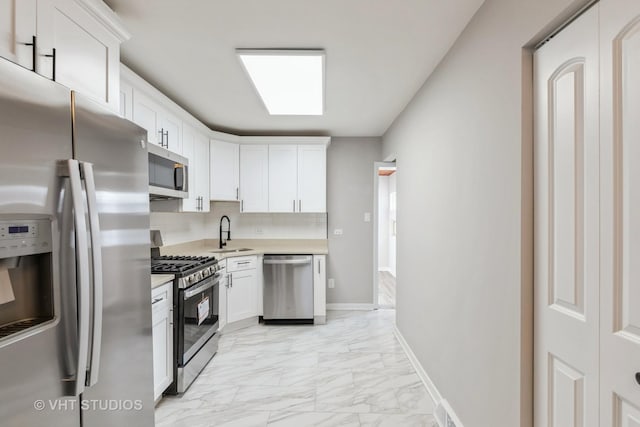 kitchen featuring sink, appliances with stainless steel finishes, backsplash, and white cabinetry