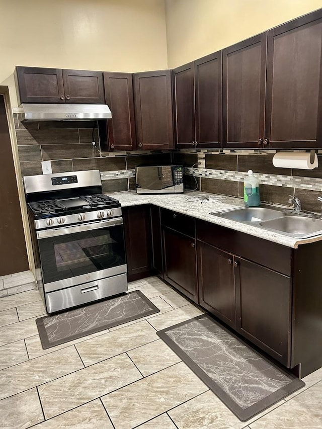 kitchen with backsplash, dark brown cabinetry, stainless steel gas stove, and sink