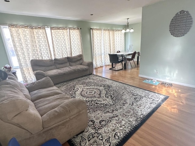 living room with hardwood / wood-style floors, a wealth of natural light, and a chandelier