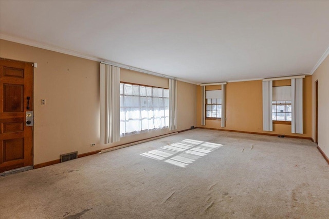 empty room with a wealth of natural light, light colored carpet, a baseboard radiator, and ornamental molding