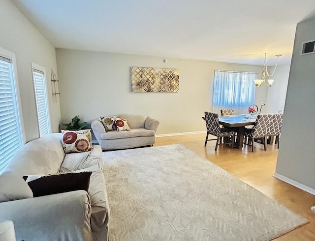 living room with hardwood / wood-style flooring and an inviting chandelier