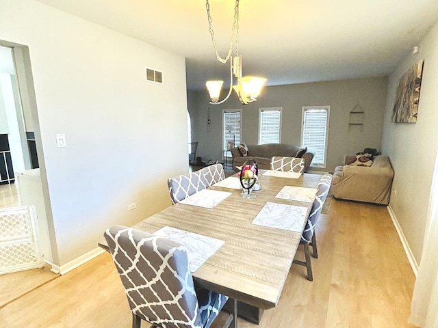 dining space with an inviting chandelier and light wood-type flooring