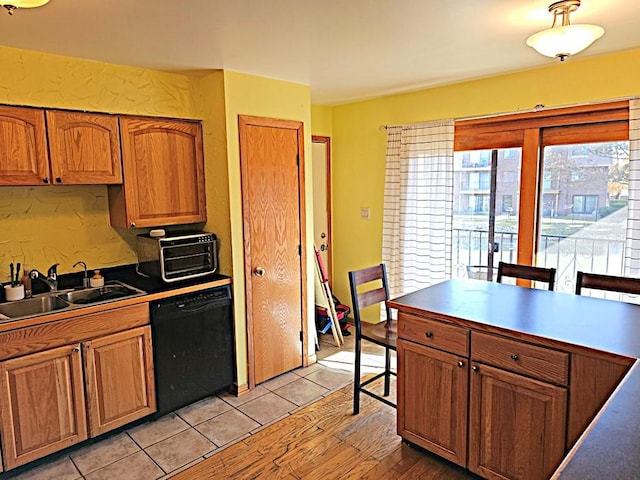 kitchen with sink, light tile patterned floors, and black dishwasher