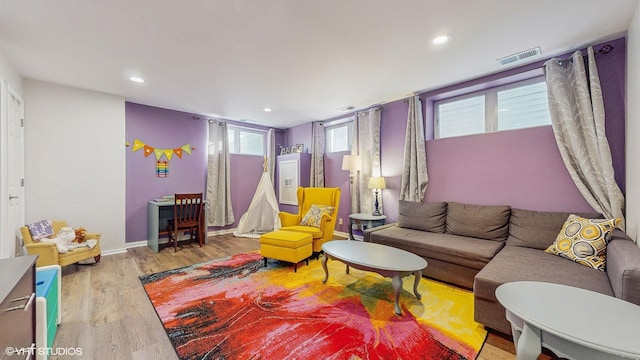 living room with baseboards, light wood-type flooring, visible vents, and recessed lighting