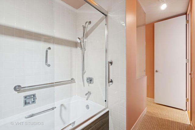 bathroom featuring tiled shower / bath combo, baseboards, and tile patterned floors