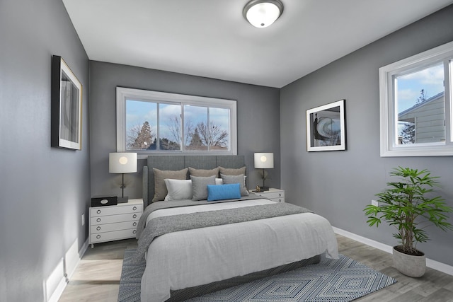 bedroom featuring light hardwood / wood-style floors and multiple windows