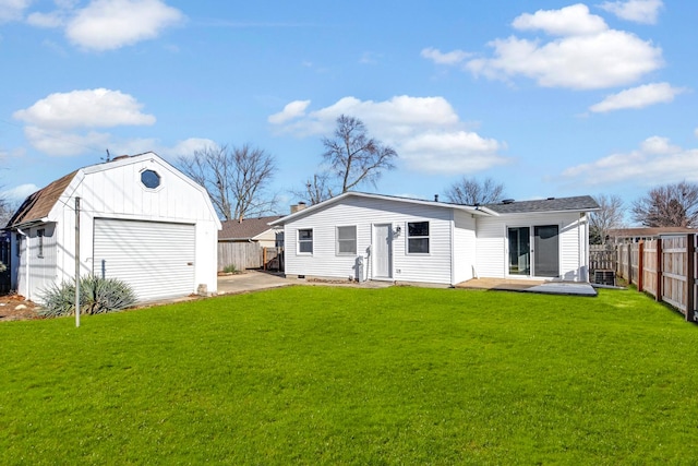 rear view of house with an outbuilding, a yard, a garage, and a patio area