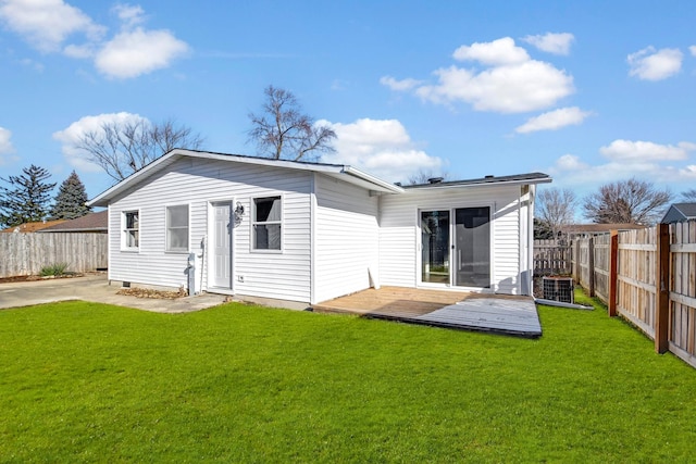 rear view of property with cooling unit, a deck, and a yard