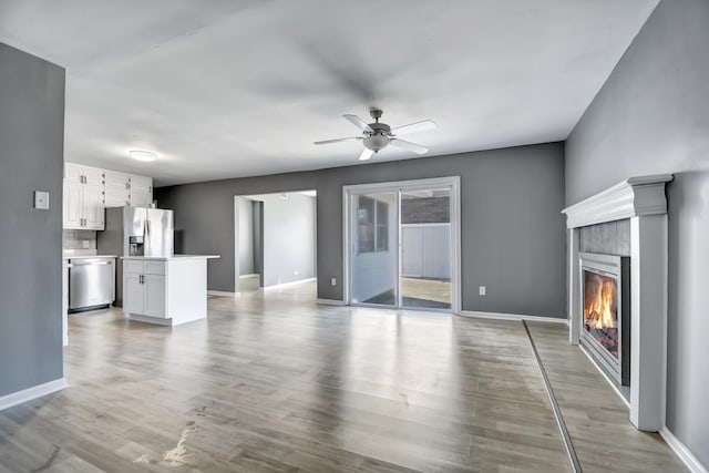 unfurnished living room featuring light hardwood / wood-style flooring and ceiling fan