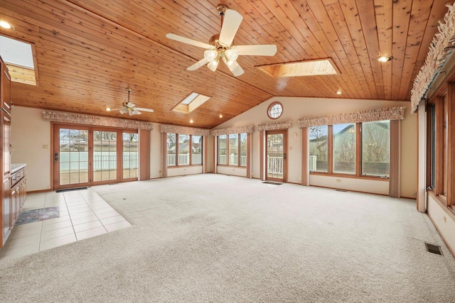 unfurnished living room featuring ceiling fan, light colored carpet, wooden ceiling, and a skylight