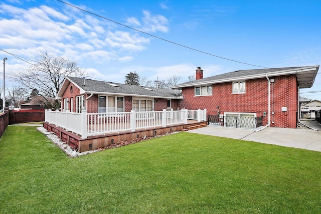 back of house featuring a lawn, a patio, and a wooden deck