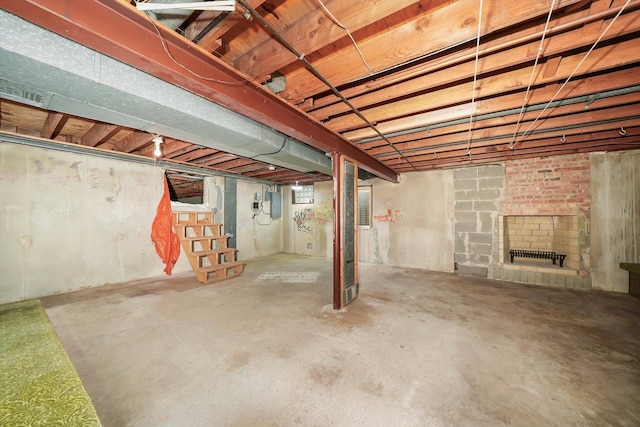 basement with a fireplace and electric panel