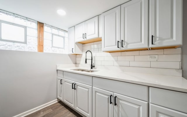 kitchen featuring light stone counters, tasteful backsplash, white cabinetry, and sink