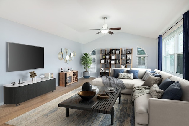 living room with ceiling fan, wood-type flooring, and vaulted ceiling