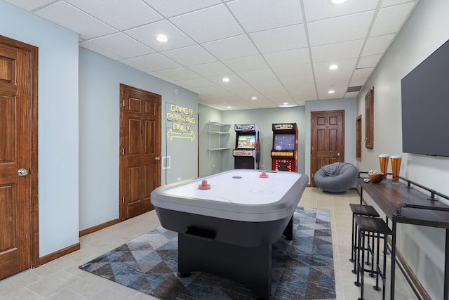 recreation room featuring a paneled ceiling and light tile patterned floors